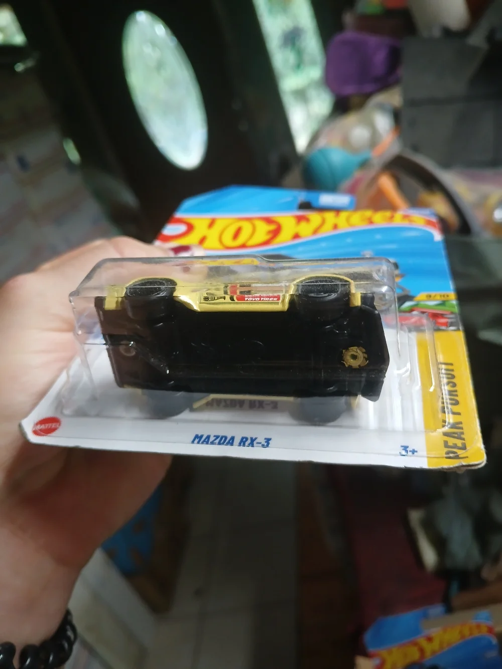 1:64 scale die-cast yellow Mazda RX-3 from the Hot Wheels Peak Pursuit series (n
